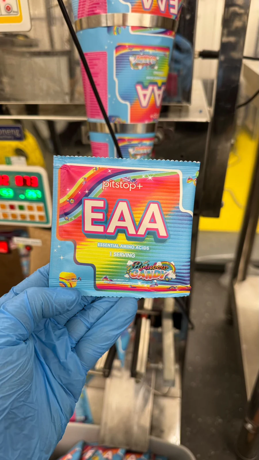 Rainbow Candy EAA sample sachet held in a blue gloved hand
